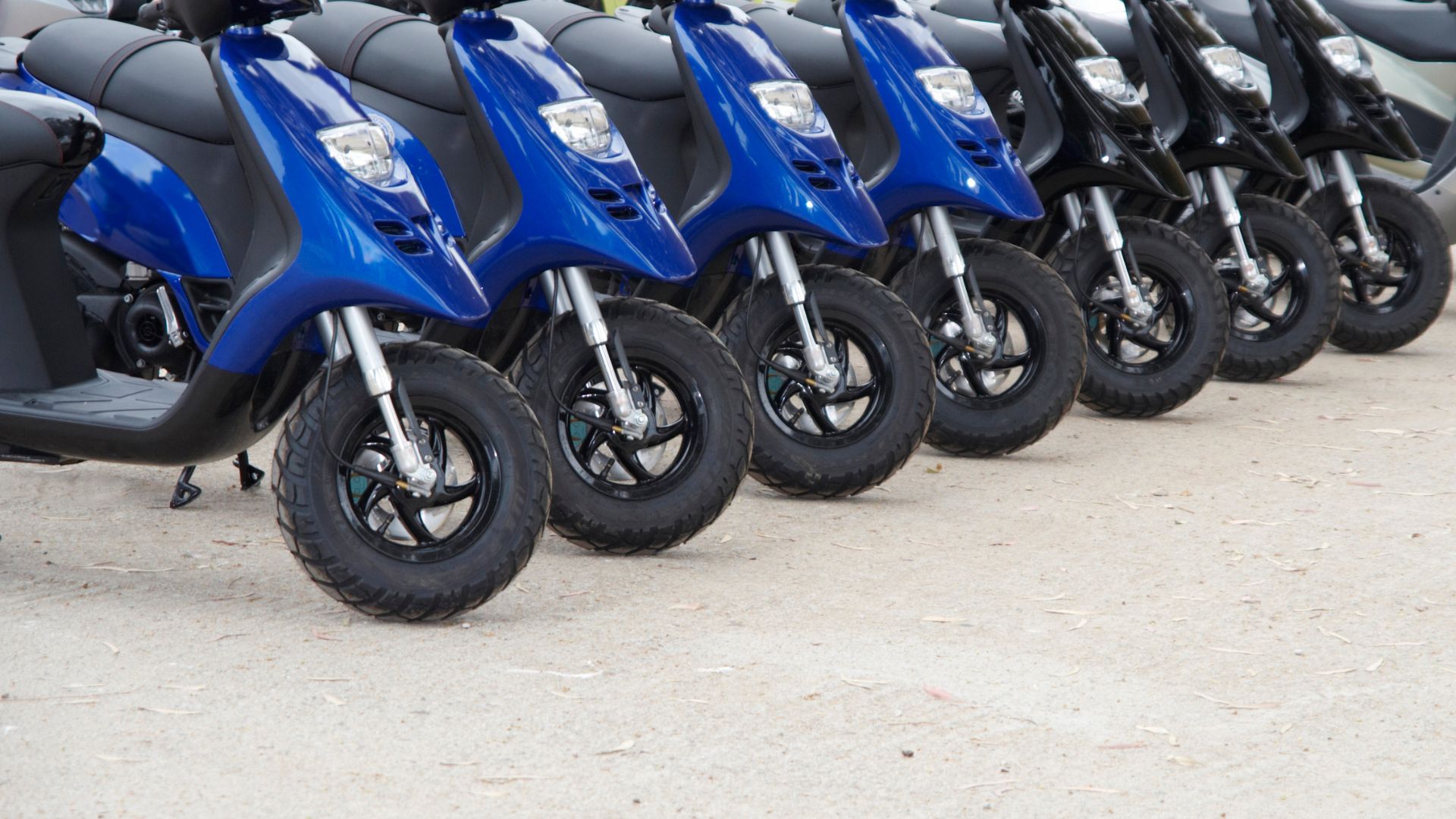 A row of blue motorcycles parked next to each other