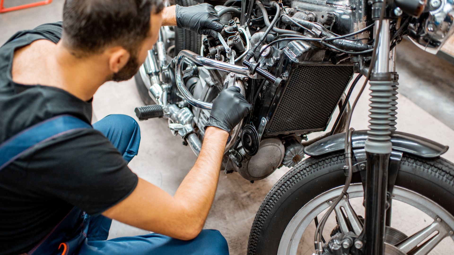 A man working on a motorcycle engine in a garage